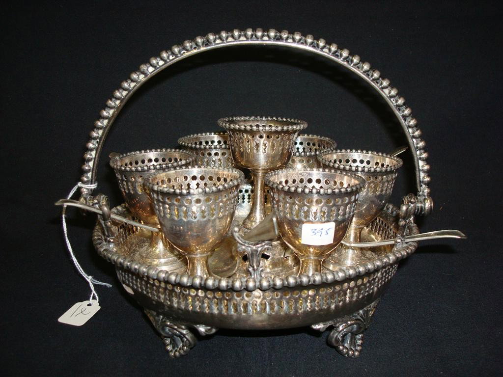 VICTORIAN SILVER PLATED EGG CADDY: Central cup with 6 surrounding cups and 6 spoons with rests. 7 high x 8-1/2 wide.