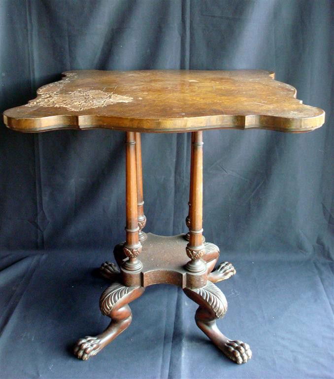 MAHOGANY PAW FOOTED TABLE: Four columnar supports. Irregularly shaped top.