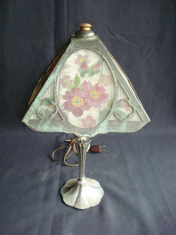 PAIRPOINT REVERSE PAINTED PANEL LAMP: Reverse painted floral and butterfly design. Signed on the base, Pairpoint and P in a diamond. Shade is numbered 7613. 17" H. 10" shade, 12" diagonal.