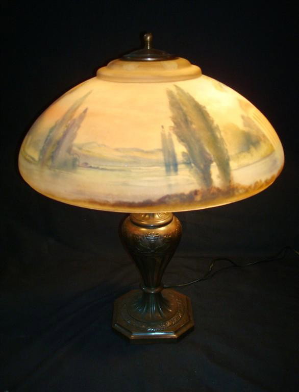 PAIRPOINT REVERSE PAINTED TABLE LAMP: Lake landscape with a columed structure. Signed Pairpoint on the shade and the base. 22" H. 18"D. shade,