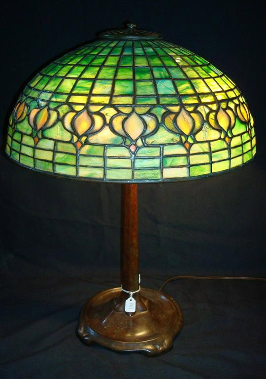 TIFFANY POMEGRANATE LEADED TABLE LAMP: On a Tiffany Studios NY bronze stick base #'d 1856 Signed Tiffany Studios New York on a tag in the leading. 22" H. 16" D. shade.