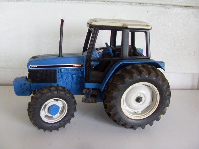 FORD 6640 TRACTOR: Blue & black Ford 6640 tractor with white roof. In original box. Manufactured by Ertl. 11" long