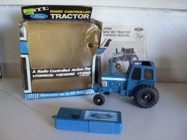 FORD TW-15 REMOTE CONTROL TRACTOR: Blue Ford TW-15 remote control tractor. With controller and original box (as is) and original booklet. Manufactured by Ertl. Stamped 2961B on sticker at base. 6" long