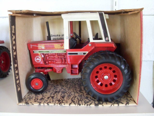 INTERNATIONAL 1586 TRACTOR WITH CAB: Red & white International 1586 tractor by Ertl. (Graphics on engine are for the 1086 model. Also has a Red Power logo on the engine.) 1/16 scale. Die-cast metal. With smoke stack, rear hitch, and stee
