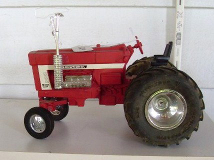 IH INTERNATIONAL FARMALL 1586 TRACTOR: Red IH International Farmall 1568 tractor. Marked 1994 Model 1568. Third in a series of four. Wide Firestone tires. Marked 2024 on the base. 10" long