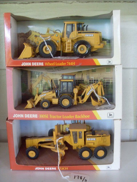 THREE JOHN DEERE CONSTRUCTION VEHICLES: Three yellow John Deere construction vehicles. A 772CH; a 310SE Tractor Backhoe; and a Wheel Loader 744H. All are 1/50 scale. All in similar original packaging. Manufactured by Ertl, 1997, 1998, & 199