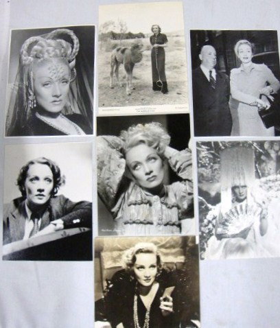 SEVEN MARLENE DIETRICH PHOTOGRAPHS: Three close ups, one candid, one seated fashion, one standing with a camel in Garden of Allah; and vintage sepia wearing a feather boa and holding a card. (Photo with necklace is fragile and has a sma