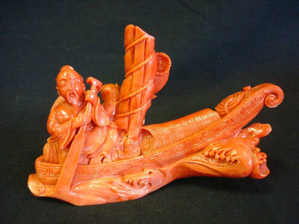 CORAL CARVING A SAIL SHIP: With single figure paddling. *** NOTE: Part of the mast has been ground*** 3 3/4: H. 6 1/4" L.