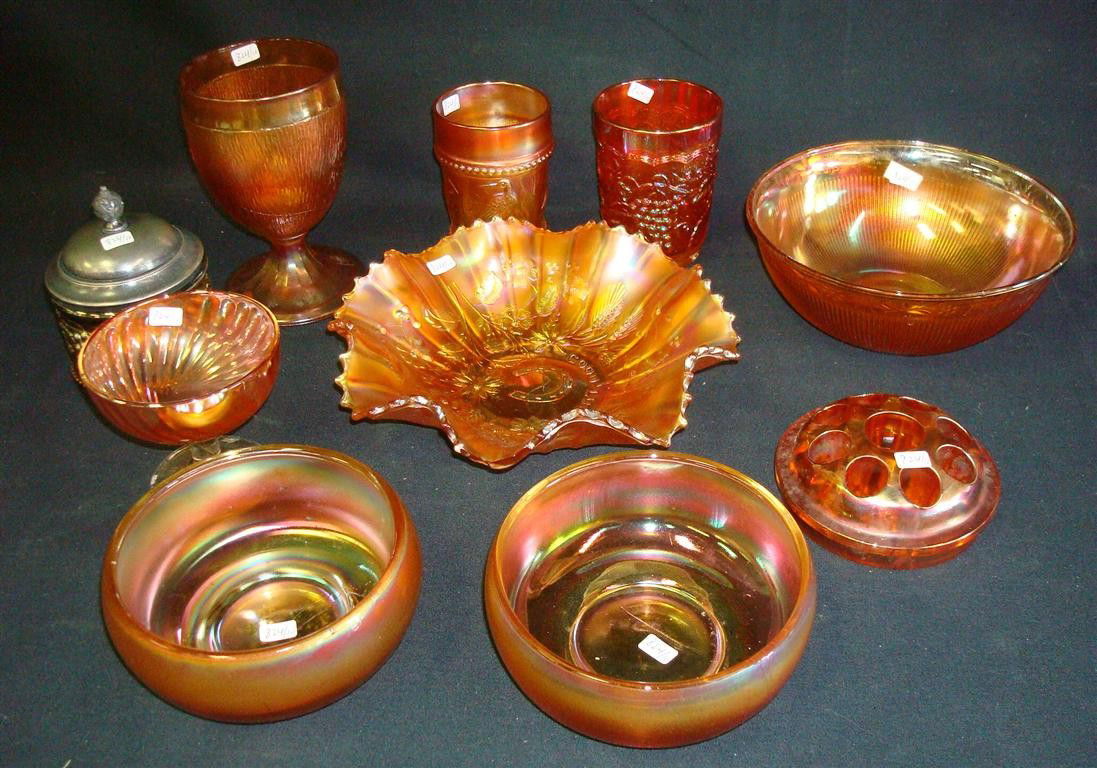 CARNIVAL GLASS LOT(10): Two orange tumblers, a ruffled bowl, a covered jar, a small pedestaled sherbert, two bowls, a larger bowl, a pedestaled tumbler and a flower frog. 9 1/2"W (largest ruffled bowl) to 3 1/2" W (smallest