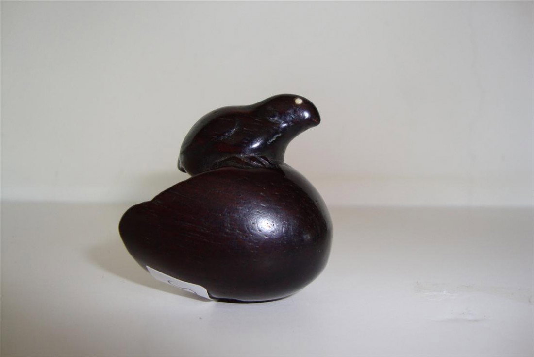 JAPANESE 19TH C. CARVED WOOD NETSUKE: A chick atop a hatched egg, ivory eyes