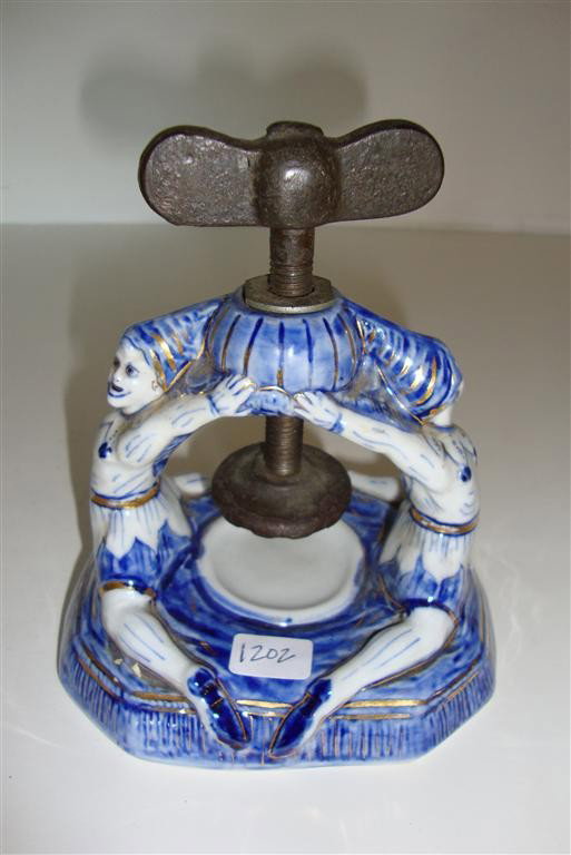 UNUSUAL BLUE AND WHITE PORCELAIN PRESS: Back to back clown figures support the central iron press. 5 1/2"H