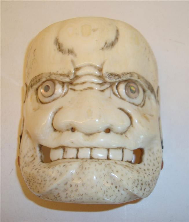 JAPANESE IVORY KABUKI MASK: Japanese carved ivory Kabuki mask with mother of pearl inlaid eyes; 2.75in. H.