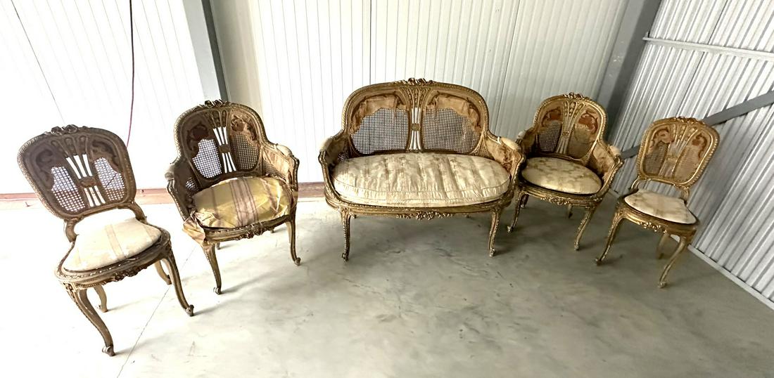 19thC. Louis XV Style Five(5) Piece Gilt Salon Set: Highly ornate five(5) piece salon set. Comprised of: settee, two(2) arm chairs, two(2) side chairs. Original gilt finish. Well carved and gilt frames with cane backs; 38in.H. x 47in.W. x 19in.D.(sette