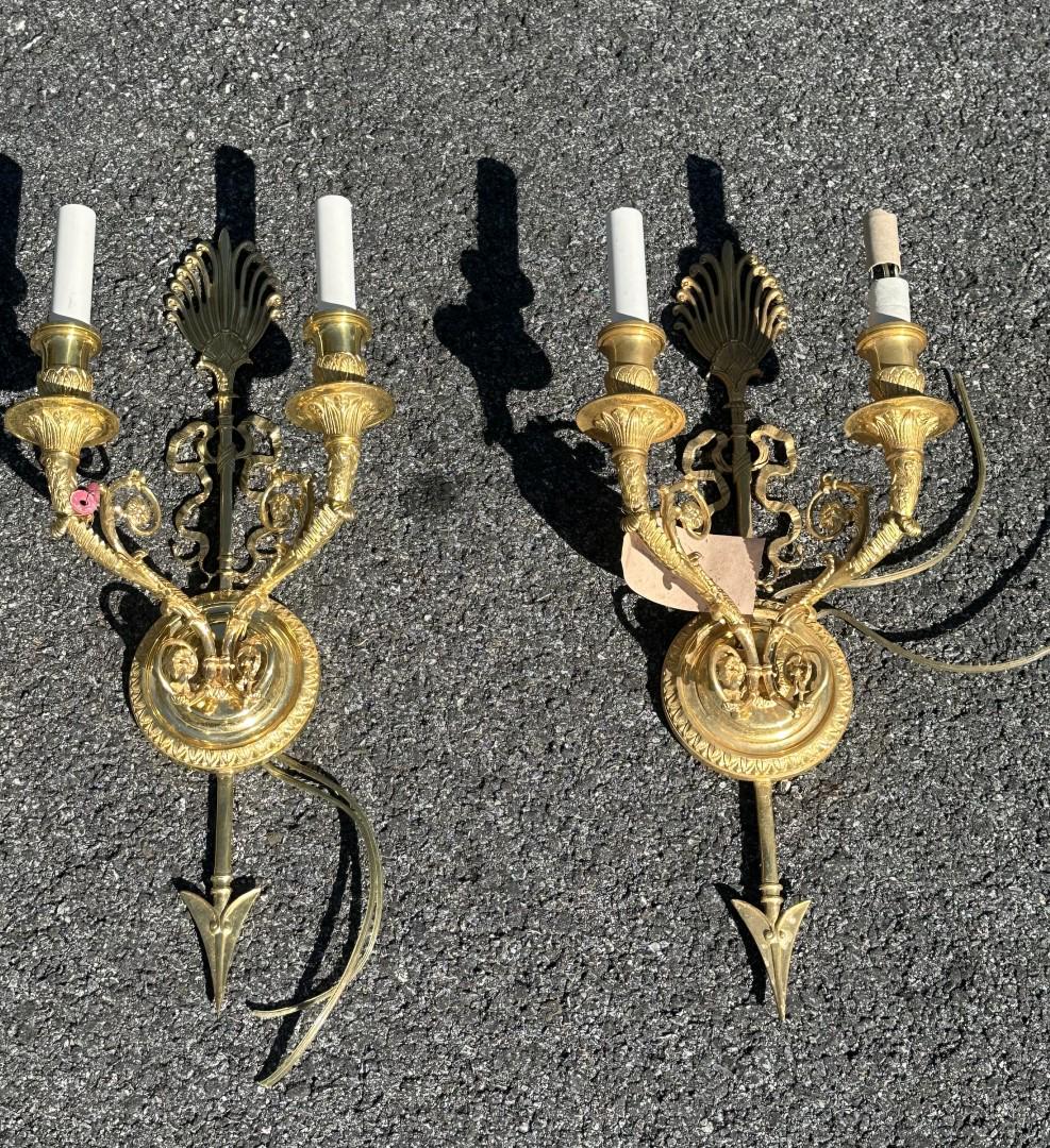 Pair of Regency Style Two(2) Light Brass Sconces: Pair of fancy two(2) light brass sconces. Bouquet and arrow design; 20in.H. x 8in.W.