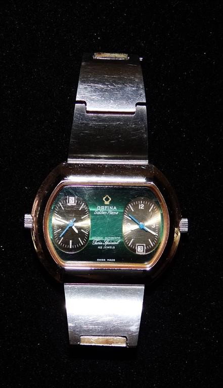 ORFINA GOLDEN FLAME MAN'S WRISTWATCH: Double Automatic Twin Special, two time zones displayed by means of two separate automatic 21 jewel movements, 42 jewels total, both with date, Steel case and bracelet with Golden Flame logo, 42mm