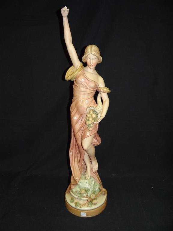 ROYAL DUX FIGURE OF A MAIDEN: Porcelain figure of a maiden with cornucopia, signed. Numbered 1701. Repair on arm and drilled for a lamp base; 33.25in. H.