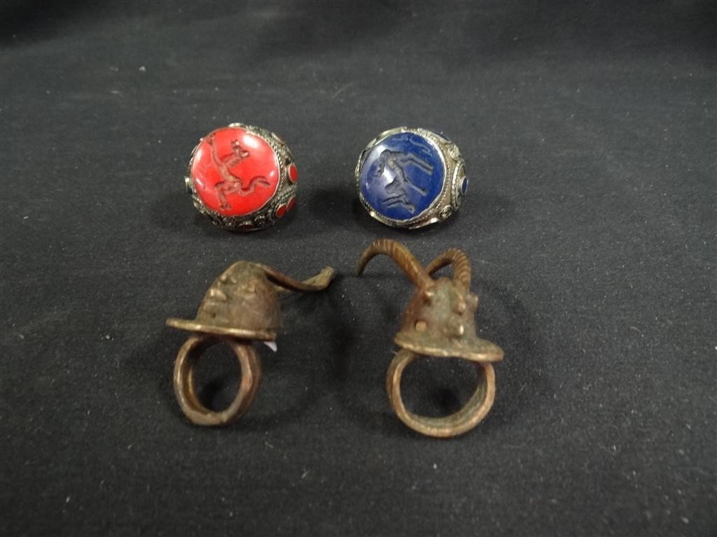 FOUR(4) AFRICAN RINGS: Four(4) African rings. Two(2) bronze animalier rings. Two(2) large rings with animalier decoration, one(1) set with lapis, one(1) set with carnelian