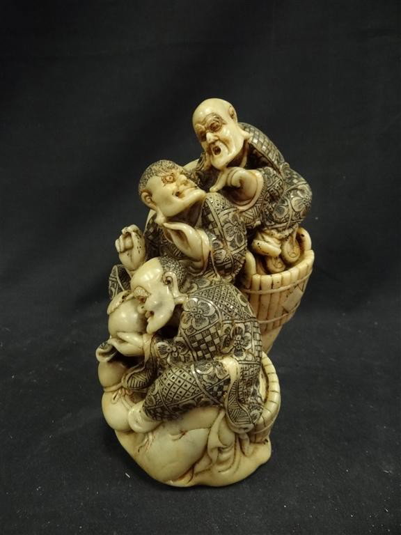 SOAPSTONE FIGURAL GROUPING: Three men in barrels 8"H