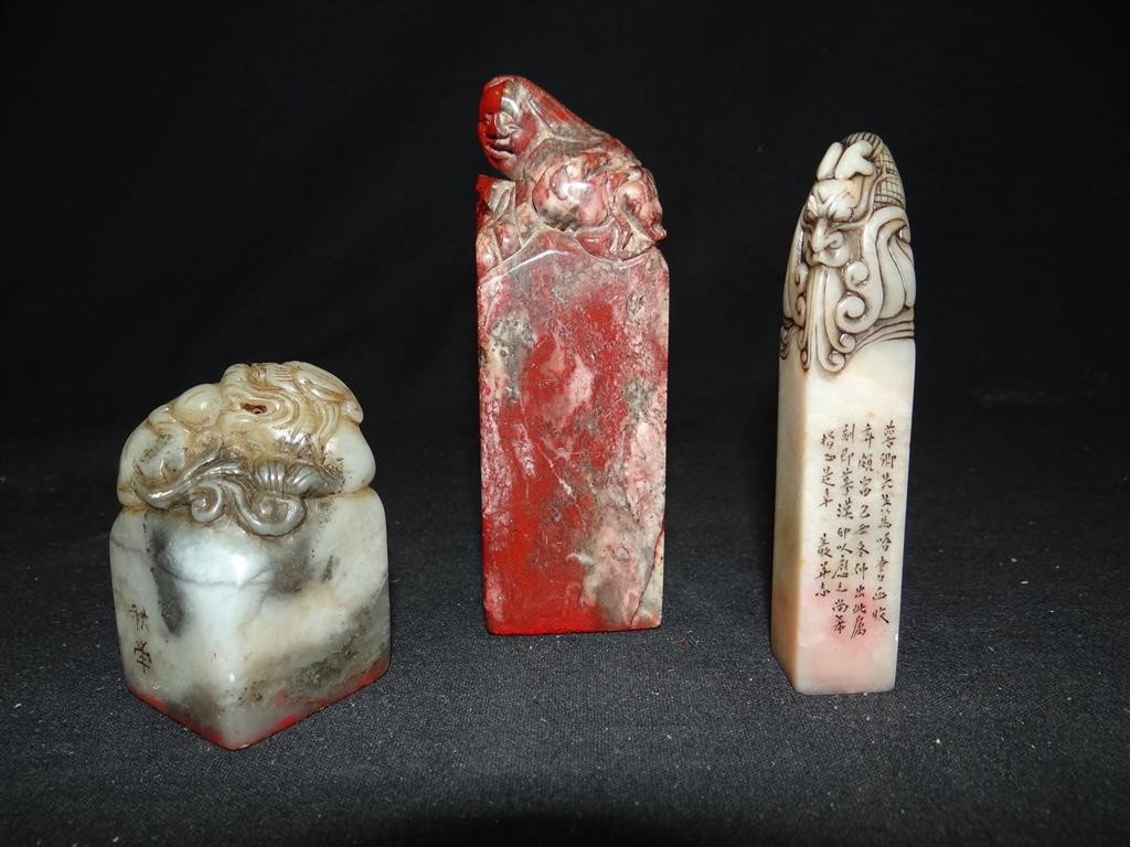 THREE CHINESE SOAPSTONE STAMPS: Decorated at the top with a dragon, a figure and a bird. All three are character signed. 2 3/8"H, 4 3/8"H.and 3 5/8"H.