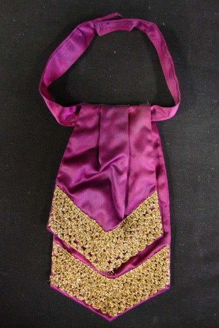 DOUBLE TIERED TIE HANDMADE BY LIBERACE: Burgundy with gold satin trim. In the early years of his career Liberace hand made his bow ties. Many of these creations are in this auction. Photos of Liberace wearing his fashion accessory are inclu