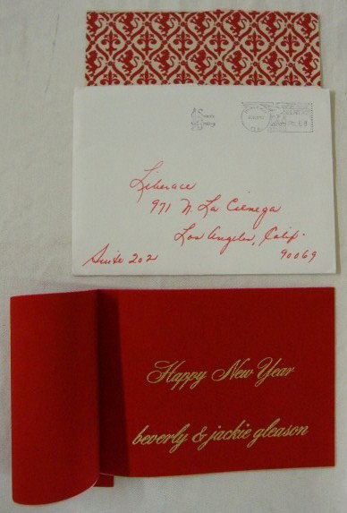 LIBERACE CHRISTMAS CARD FROM JACKIE GLEASON: Red velvet on the interior and the exterior, gilt lettering. Beverly and Jackie Gleason in original 1972 envelope with date stamp for 1972.