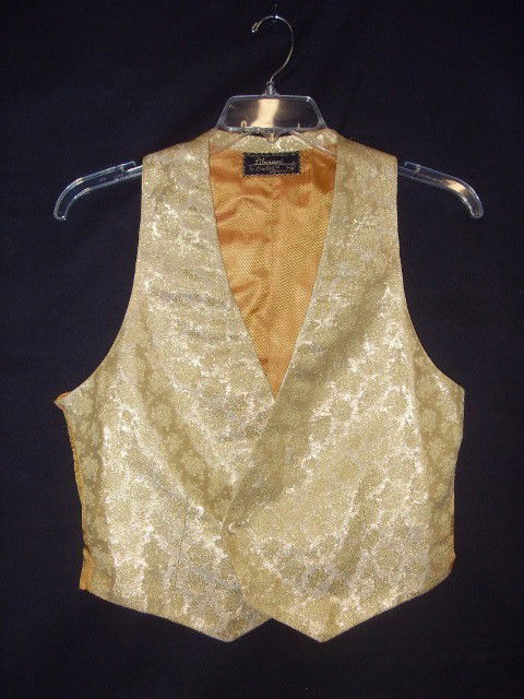CUSTOM MADE LIBERACE VEST: Gold brocade with silk lining. Label "Exclusively tailored for Liberace by Ortiz's Galveston. One button closure and one button at inside for tailored look.