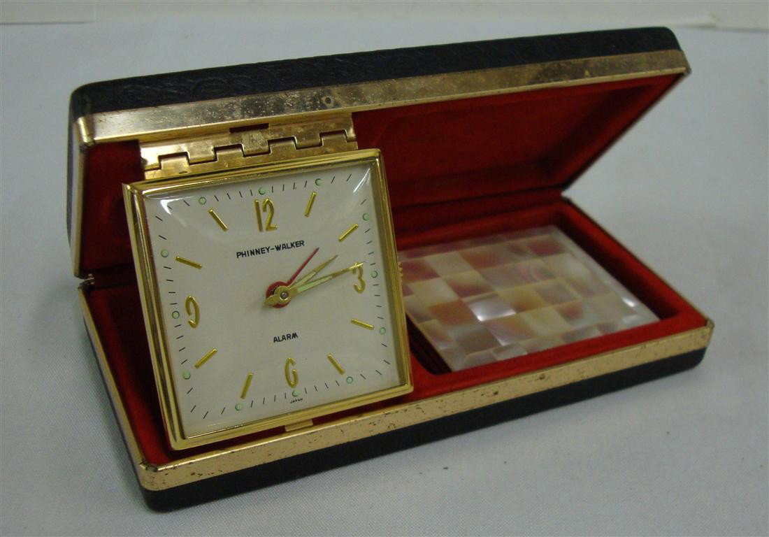 LIBERACE'S TRAVEL ALARM AND MIRROR: A Phinney-Walker travel alarm, folding variety, in case and a mother-of-pearl mirrored compact.