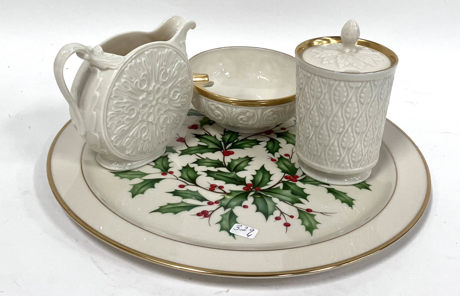 Collector;s Lot of Lenox. (4): Included in the lot is a gilt decorated ashtray, a covered suar and a creamer and a Christmas plate. 12 1/2"D (plate); 5"W (ashtray), 5"H (creamer) and 4 1/4"H (sugar)