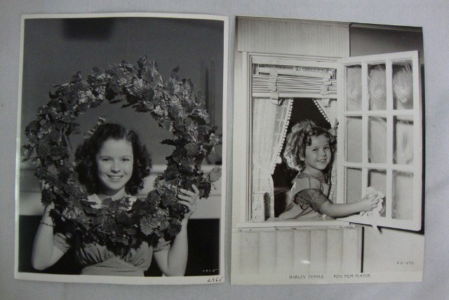 SHIRLEY TEMPLE BY OTTO DYAR & CLARENCE S. BULL: Shirley Temple "washing windows" in her portable dressing room on the Fox lot. Publicity snipe for same and Bright Eyes. Back Stamp for Fox Film and Otto Dyar. 1941 Christmas portrait, cardboard stock