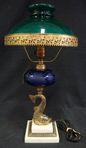 PAIRPOINT DOLPHIN BASE TABLE LAMP: Cobalt patterned glass font decorated with grapes and grape leaves. Dolphin rests on a tiered marble and brass base. Cased glass shade. 17"H.