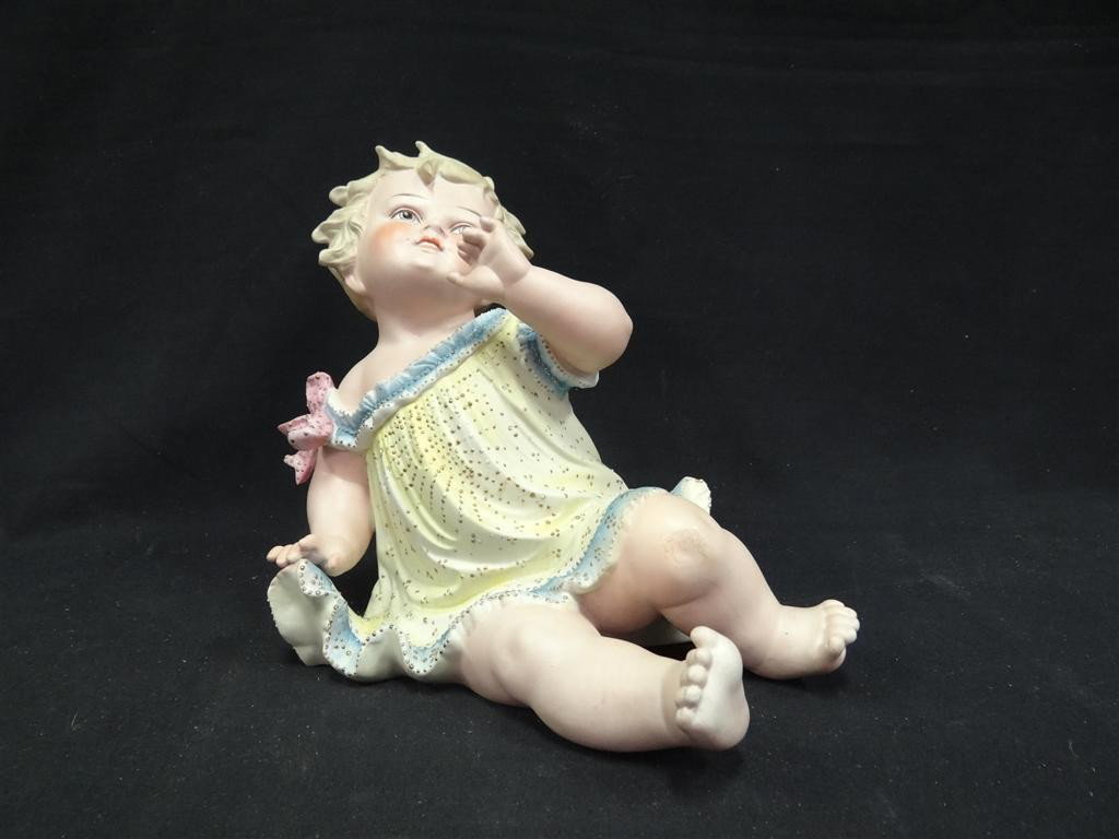 HUEBACH PORCELAIN PIANO BABY: Bisque porcelain, hand painted piano baby; 10.5in. H.