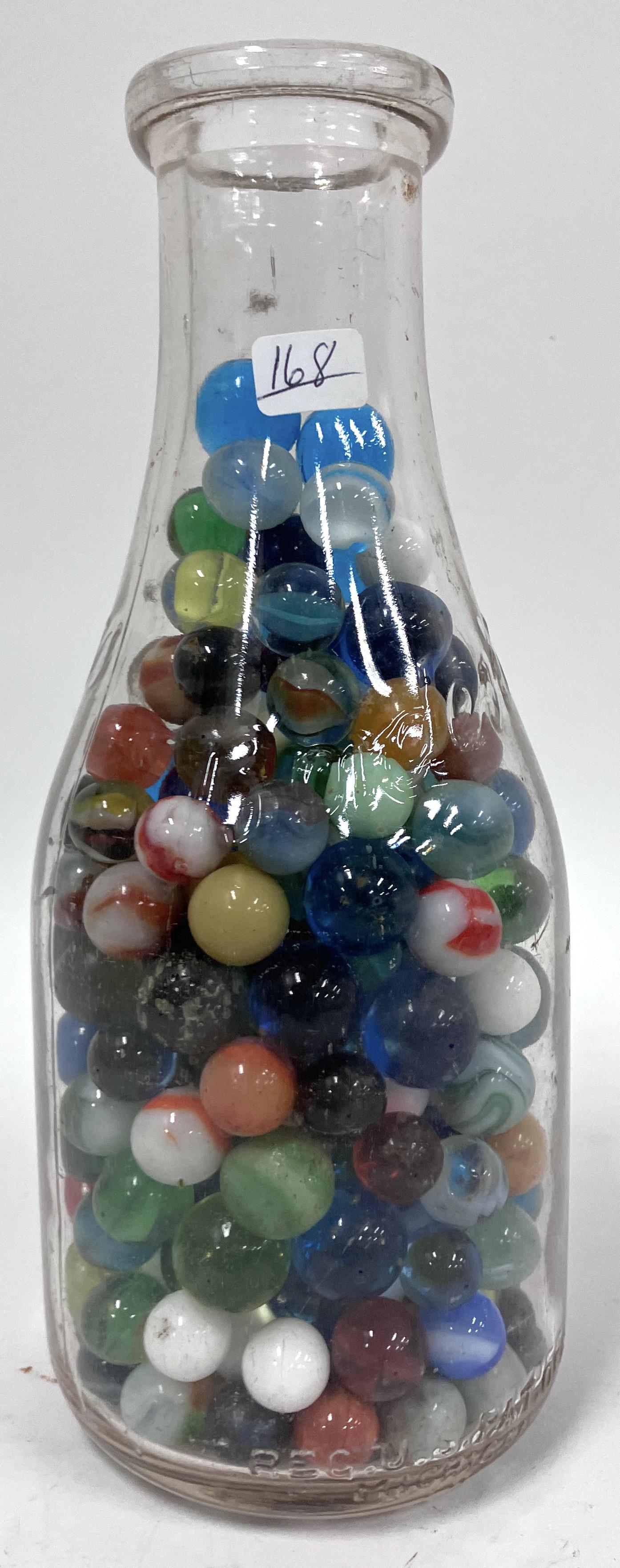 Collector's Marbles. Borden's Milk Bottle Full: 9" H vintage Borden's milk bottled filled with various colored and types and sizes of marbles