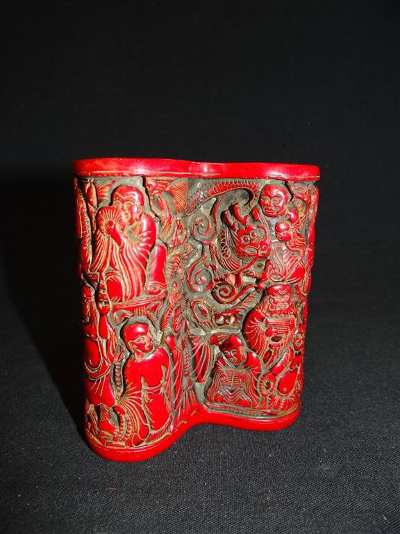 EARLY CHINESE CINNABAR BRUSH POT: Early Chinese cinnabar brush pot. Unusual form with all over figural carved decoration; 4in. H. x 3.5in. W.