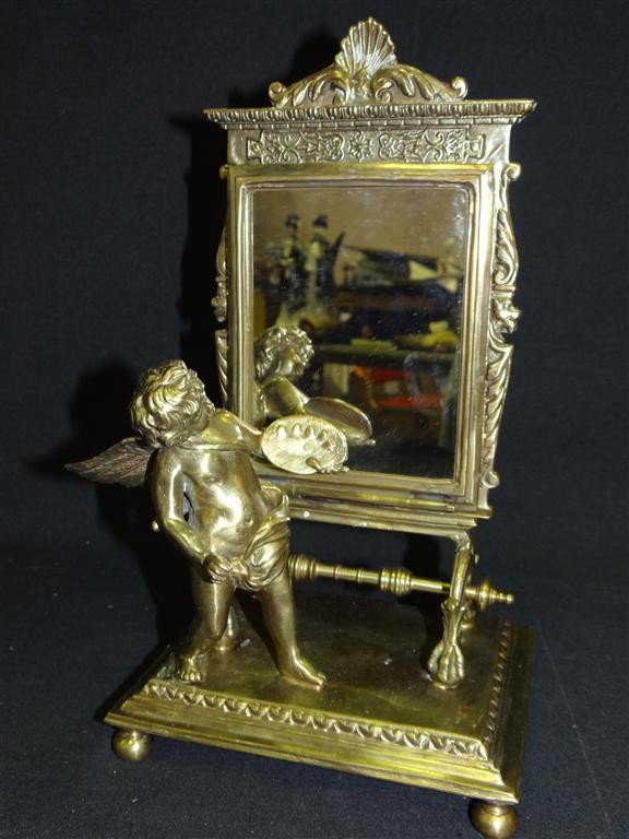 BRONZE DRESSING TABLE MIRROR: With a full bodied cherub on the ball footed base. 11H. 6 1/2"W.