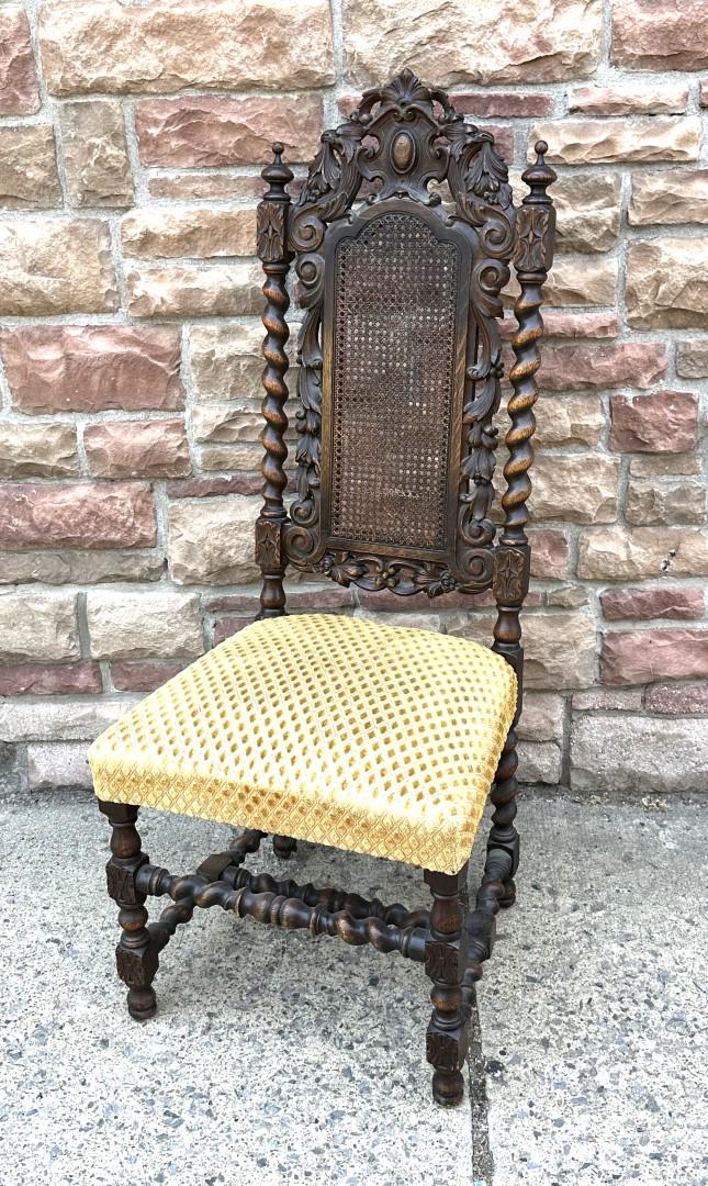 English Heavily Carved Oak Chair: Heavily carved oak chair. Spindled sidesand stretcher base. Caned back and upholstered seat; 49in.H. x 20in.W. x 20in.D.