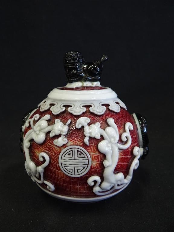 CHINESE PEKING GLASS OVERLAID JAR: Cut with dragons Three color glass, brown, white and green. Original lid with foo dog finial. Chien Lung mark 6 1/4"H. 5"D.