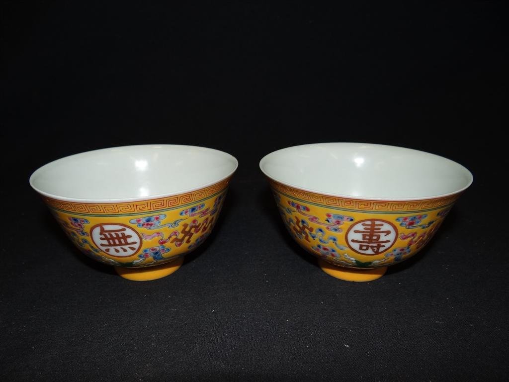 LATE 19TH C. PR. OF CHINESE PORCELAIN BOWLS: Yellow ground painted in famille rose enamel with buddhist medallions. Six character Guangxu mark. 2 1/2"H. 4 1/4"D.