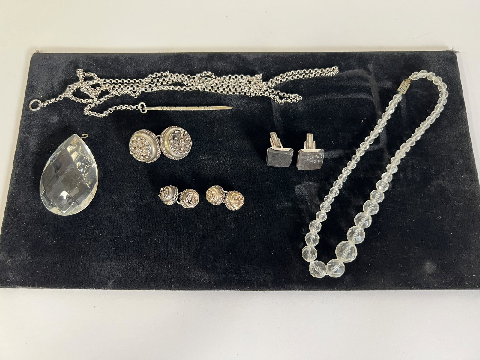 Collectors Lot of Jewelry inc. Sterling (8): Two pr. of sterling buttons marked JTR and 835; a large pr of "silver buttons",, unmarked; a large faceted crystal; a cut crystal necklace a pr. of sterling silver cuff links with onyx marked Hand Mad