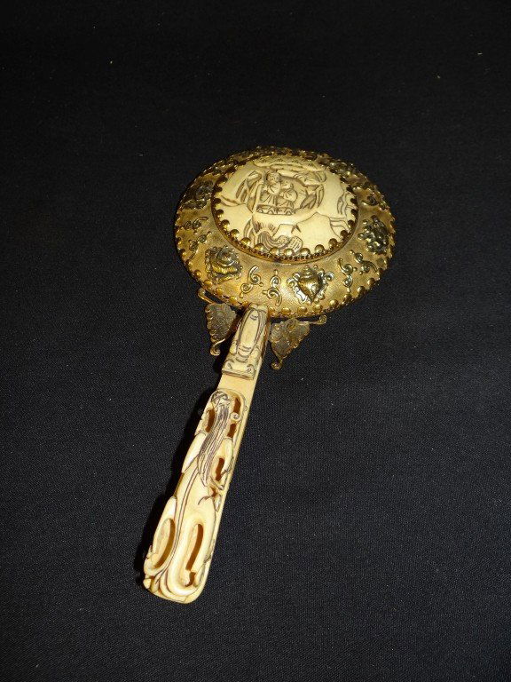 Chinese ivory and brass mirror: Ornate brass mirror with ivory handle carved with dragon and ivory insert decorated with figures; 9in.