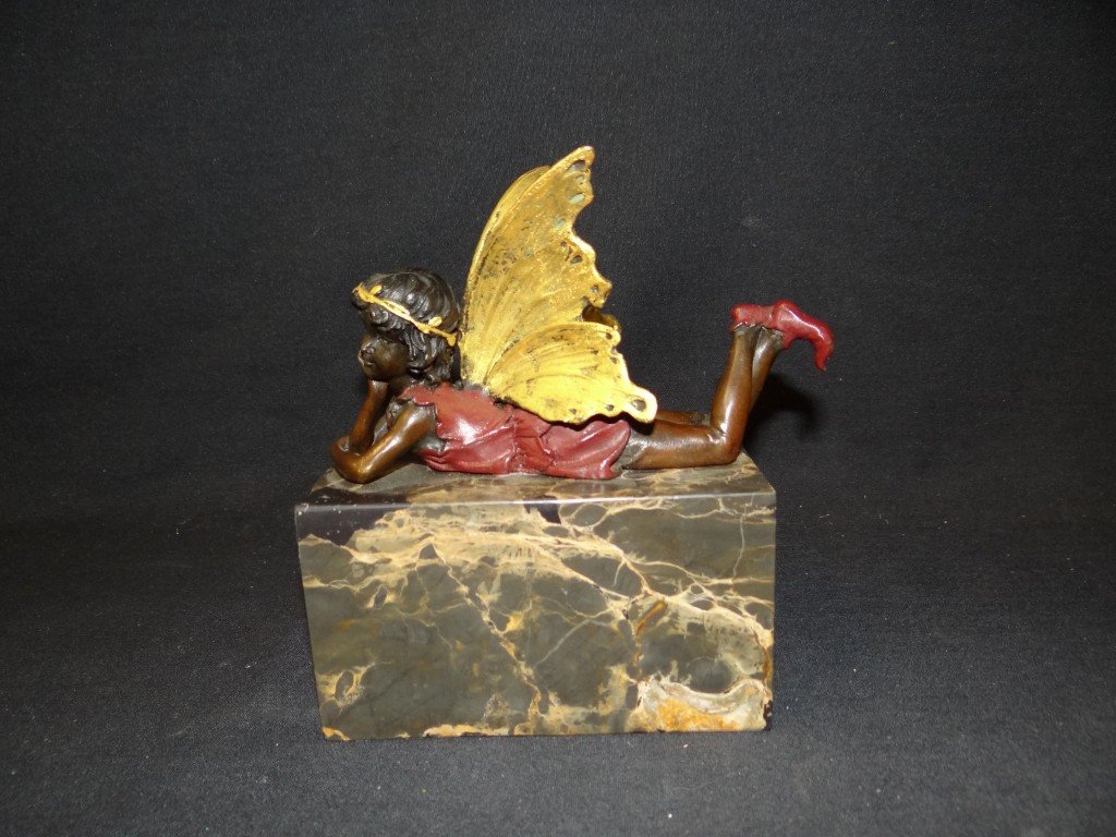 Milo; Bronze figure of a fairy: Bronze figure of a reclining fairy. Gilt decorated wings and halo. Marble base; 6.5in. H. x 6in. W.