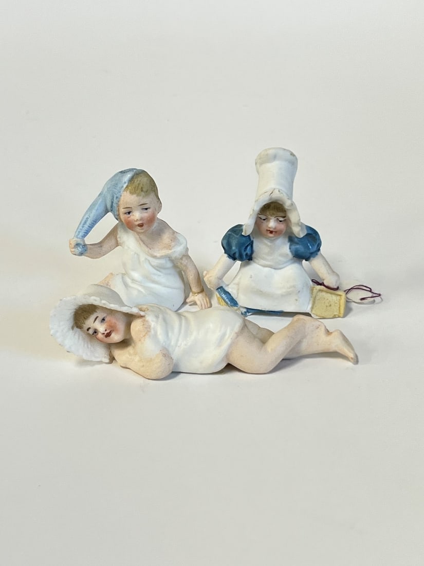 Collectible Figures Inc. Heubach(3): 2 marked at underside. "Sleeping Beauty" is 1"H by 4"W. Girl with a dust pan is 2.25"H by 2"W. Boy holding stocking hat is 2.25"H by 2 1/8"W.