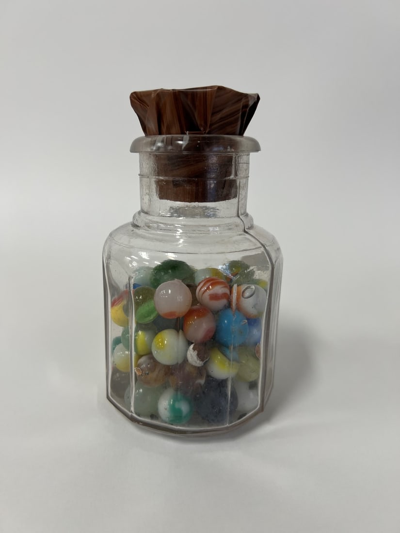 Paneled Glass Jar of Marbles.: Varying sizes inc. oversized. Various types including clear, colored and marbleized as well as agate type.