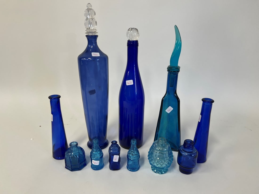 Collector;s Lot of Antique Blue Art Glass (11): Included in the lot is a cobalt tall decanter with clear glass triple tiered stopper (mnor chip on stopper) ; a blue decanter with modernist stopper ; a pr. cobalt blue bud vases; a cobalt bottle with