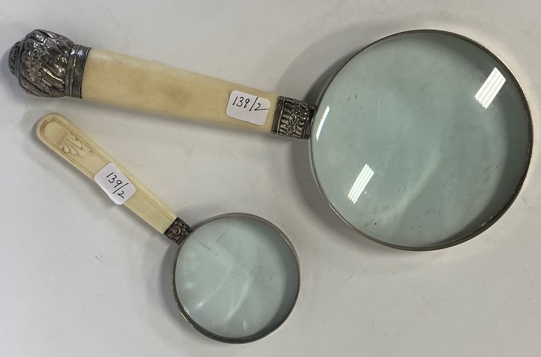 Vintage Magnifying Glasses (2) One Reed & Barton Mtd.: Two magnifying glasses in the lot. One large, 10 1/4" L with 4 1/4"W magnifying glass. Marked R & B and with eloonated number. Fancy silver repoussed mounts. Second magnifying glass, smaller, 6"L. Bot