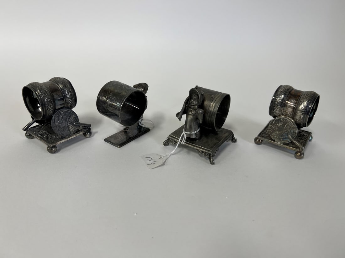 American Victorian Figural Napkin Rings (4): Kate Greenaway girl with rifle on her shoulder, Simpson, Hall & Miller, marked at the underside; Meriden #208, napkin ring raised aloft by two fans with butterfly underneath on a ball footed repoussed