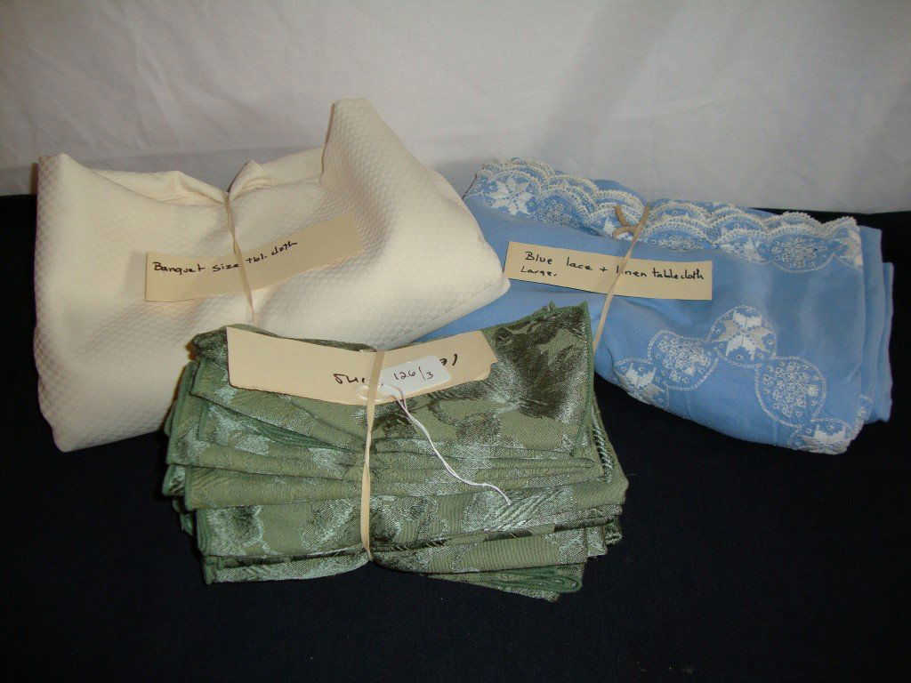 Lot of Linens: Lot includes blue linen tablecloth with lacy embroidered edge; banquet size ivory tablecloth and sixteen napkins