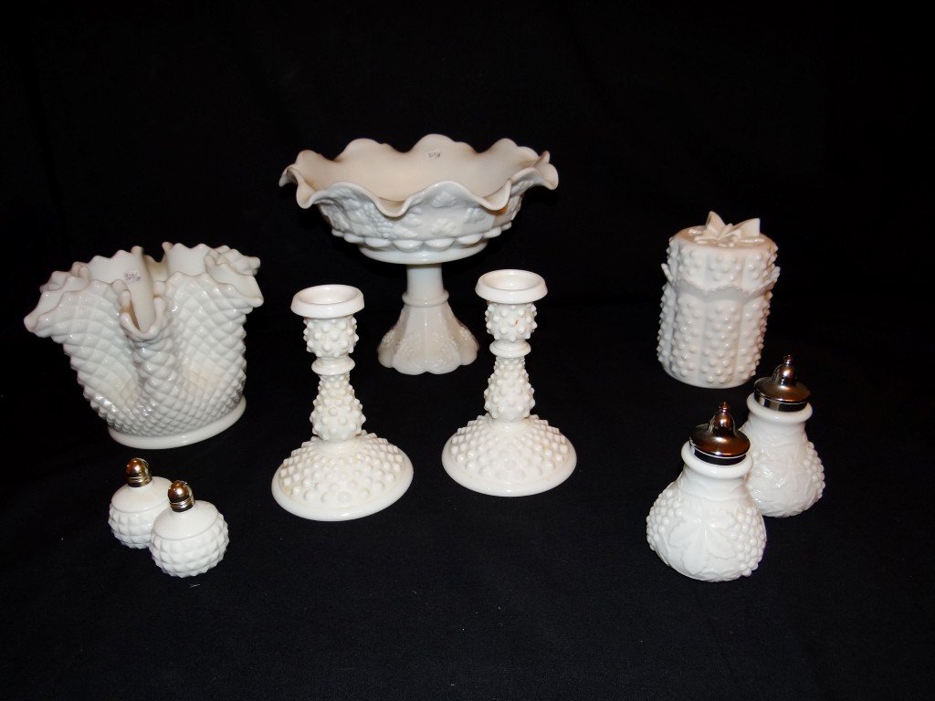 Large lot of Milk Glass inc. Fenton (9 pcs.): Large milk glass compote, a ruffled vase, a pr. Candleholders, a covered box with a Fenton label; two pairs of salt peppers. Varying sizes. One Candlestick with a chip