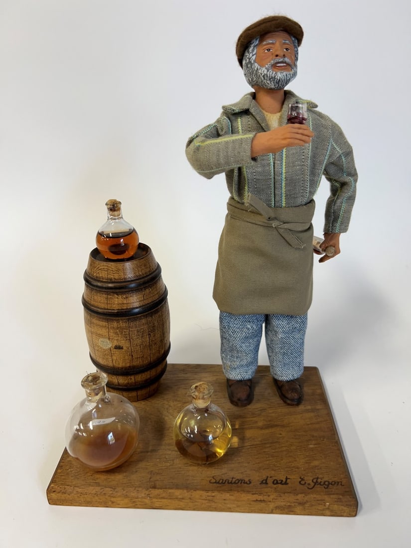 Folk Art Drinker Figure with Keg & Bottles: Terra Cotta face. Fabric clothes. On a wooden stand wtih flasks. Polychromed features. 11 1/2"H x 8"W x 5.5"D.