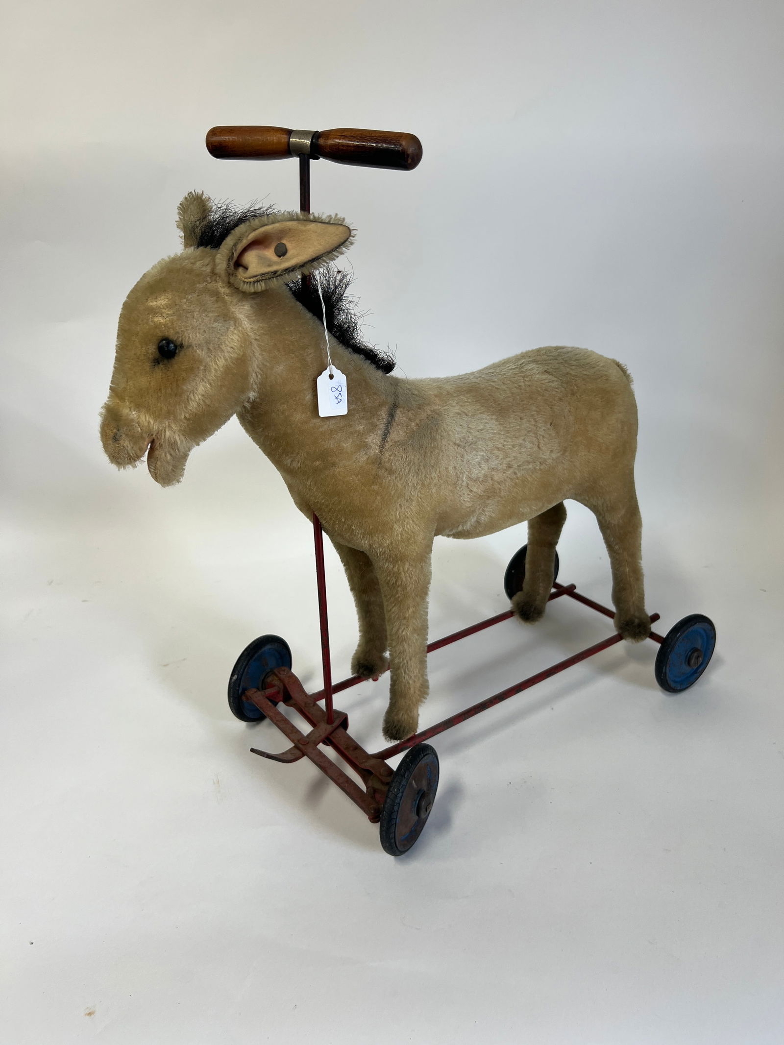 Vintage Steiff Ride On Donkey Toy: On a wheeled platform. Has Steiff button in ear. 20 1/4"H and the wheeled platform 17 1/2"L