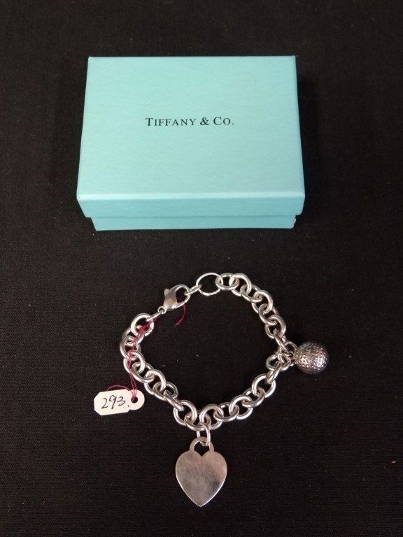 Tiffany & Co. silver bracelet: Sterling silver link bracelet with heart charm and golf ball 2.25in. D. With box